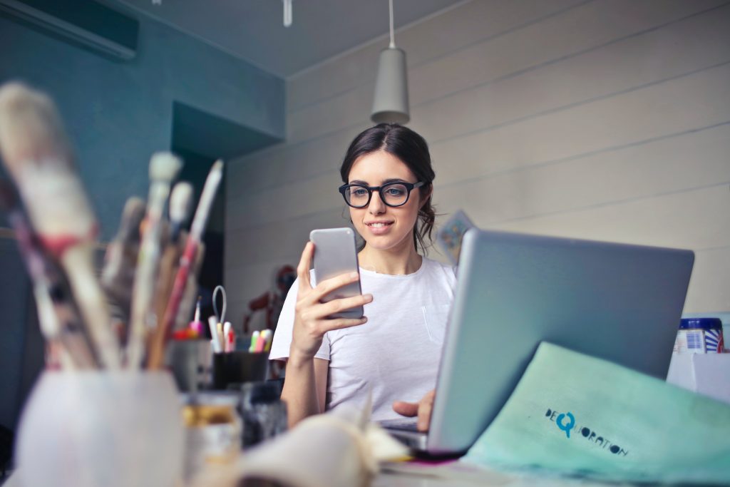Young woman excitedly checking her smartphone.
